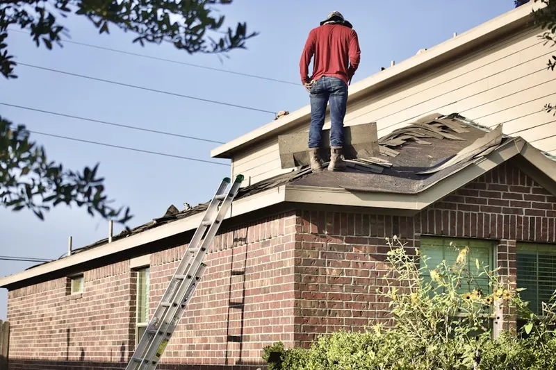 Professional roofer working on a residential roof in Winton Place